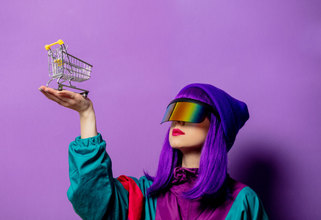 "A stylish woman wearing VR glasses and an 80s tracksuit pushes a shopping cart against a violet background."